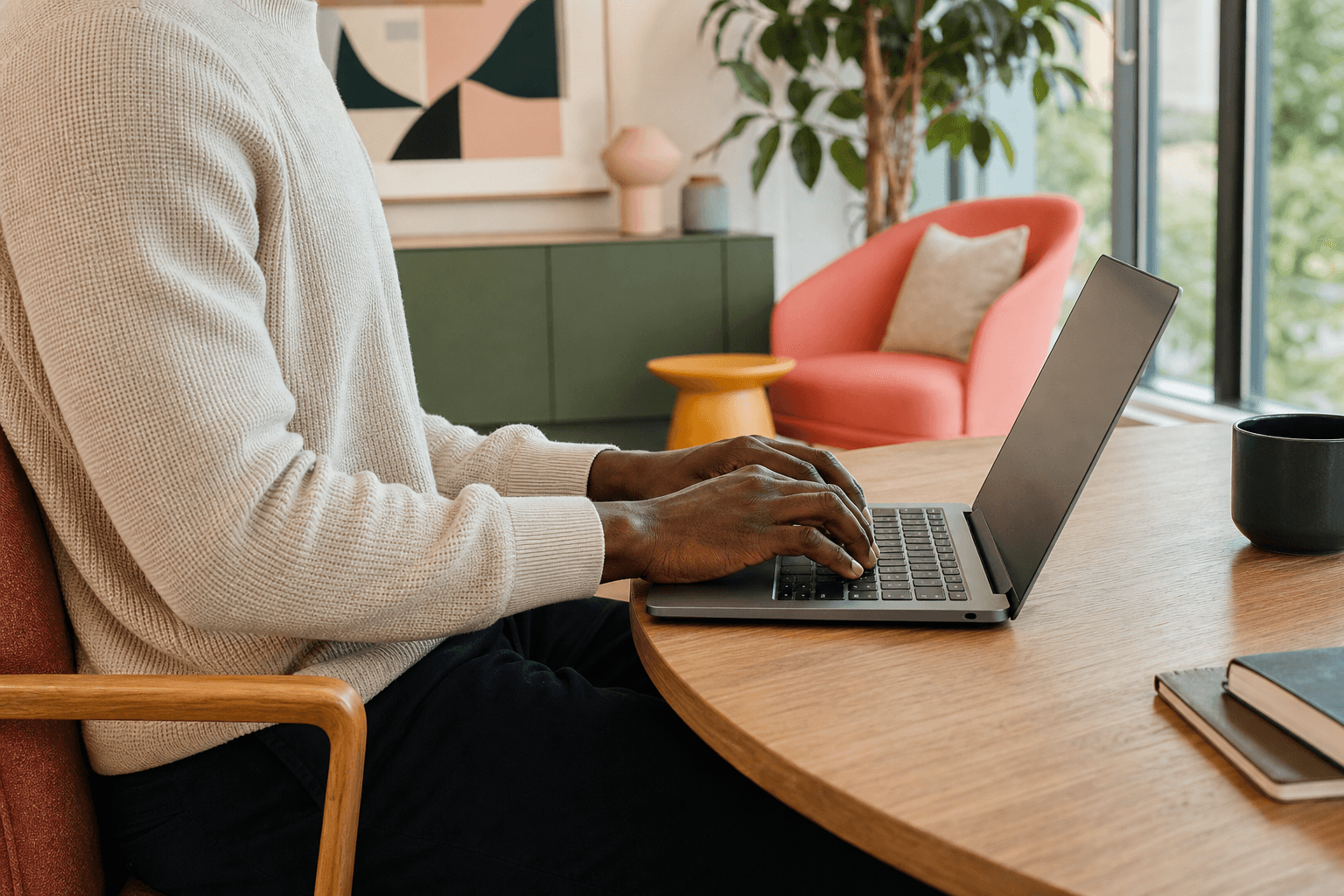 A technical professional typing on a laptop in a bright office